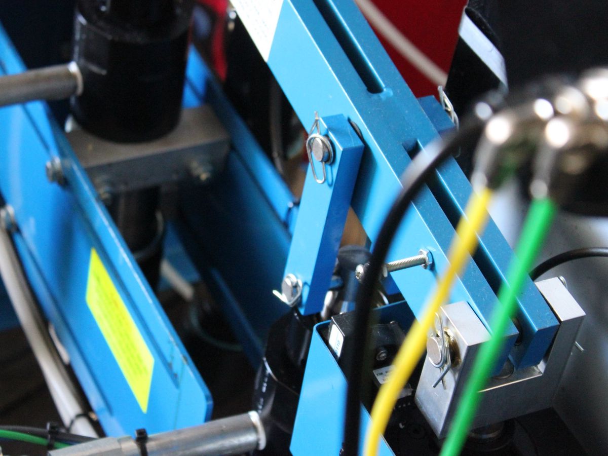 Close-up of the blue frame, valves, and heated lines on the two-part polyurethane dispensing machine